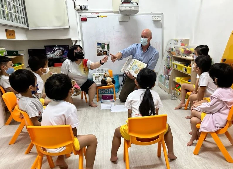 John Cunningham and Veronica engaging children in a story
